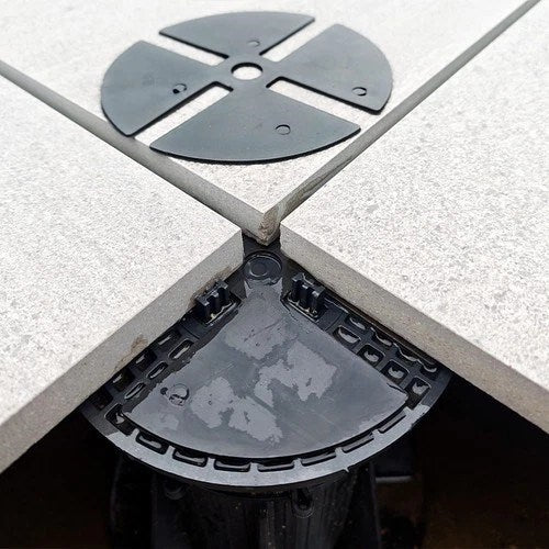 Mehrere Stelzlager stützen eine angehobene Terrasse während der Montage